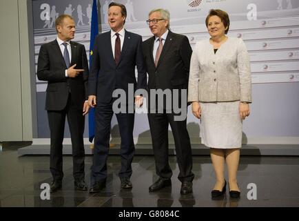 Prime Minister David Cameron (second left) is welcomed to the Eastern Partnership Summit in Riga, Latvia by President of the European Council, Donald Tusk (first left), President of the European Commission Jean Claude Juncker (second right) and Latvian Prime Minister Laimdota Straujuma. Stock Photo