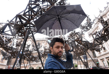 Artist Conrad Shawcross poses with his installation, 'The Dappled Light of the Sun, 2015' in the courtyard at the Royal Academy of Arts in London. Stock Photo