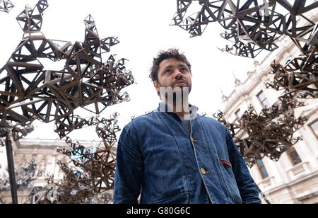 Artist Conrad Shawcross poses with his installation, 'The Dappled Light of the Sun, 2015' in the courtyard at the Royal Academy of Arts in London. Stock Photo