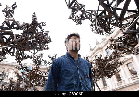 Artist Conrad Shawcross poses with his installation, 'The Dappled Light of the Sun, 2015' in the courtyard at the Royal Academy of Arts in London. Stock Photo