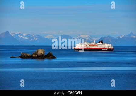 Nordlys Hurtigruten coastal ferry northbound, Lofoten, with snowy mountains, blue Stock Photo