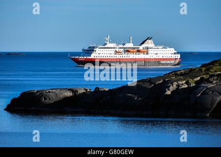 Nordlys Hurtigruten coastal ferry northbound, Lofoten, with snowy mountains, blue Stock Photo