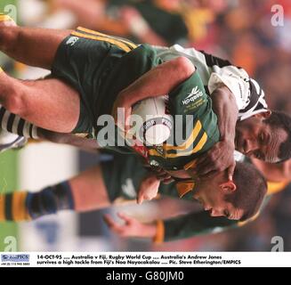 14-OCT-95 .... Australia v Fiji, Rugby World Cup .... Australia's Andrew Jones survives a high tackle from Fiji's Noa Nayacakalou Stock Photo