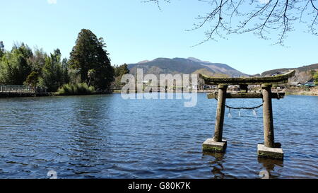 A floating torri gate sits peacefully in the quiet Kinrinko lake at Yufuin, Japan Stock Photo