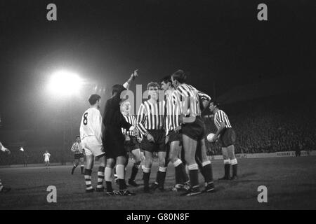 Players crowd round the referee to protest a free kick awarded to Preston North End in the Football League Division Two match against Millwall at The Den. Stock Photo