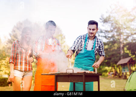 Friends having a barbecue party in nature  while having a blast Stock Photo