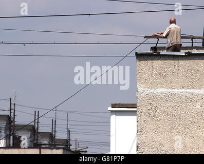 technicain stand on a roof to connect fiber-optic cables. Stock Photo