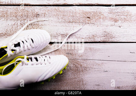 Soccer cleats against wooden background. Studio shot. Copy space. Stock Photo