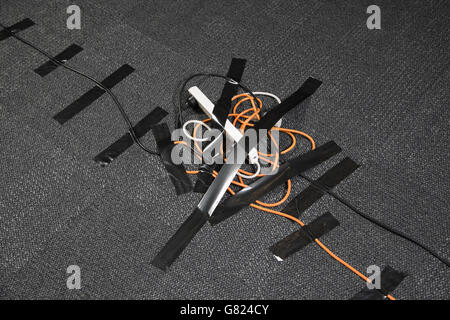High angle view of cables and electric plug attached on black carpet Stock Photo