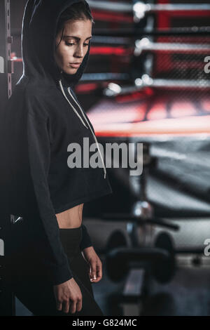 Side view of thoughtful young woman standing at gym Stock Photo