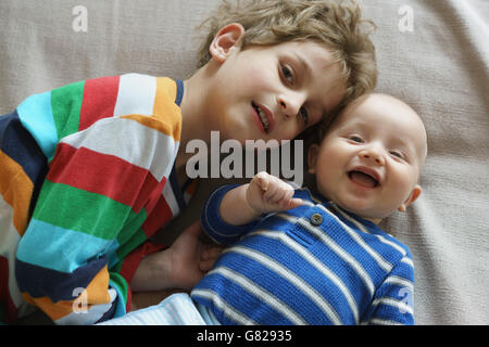 High angle portrait of brothers lying on bed at home Stock Photo