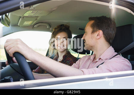 Smiling couple looking at each other while traveling in car Stock Photo