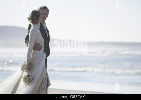 Romantic bride and groom looking at each other at beach Stock Photo