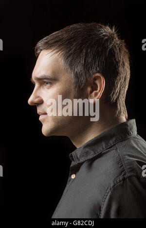 Profile view of man against black background Stock Photo