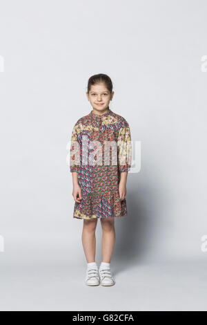 Portrait of smiling girl standing against door Stock Photo - Alamy