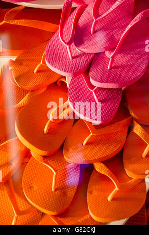 Full frame shot of pink and orange flip-flops seen through glass at store Stock Photo