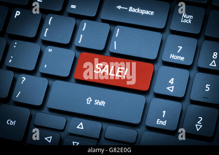 Close-up laptop keyboard. The focus on the Sale key. Toning is blue. Stock Photo