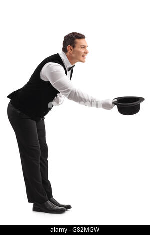 Full length profile shot of a young male waiter bow down and taking off his hat isolated on white background Stock Photo