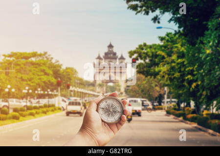 Hand man holding compass on road Victory Gate Patuxai, Vientiane, Laos, Southeast Asia Stock Photo