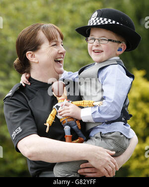 48-year-old Margo Sinclair with her grandson 4-year-old Harry O'Neill after taking part in a police passing out parade at the Scottish Police College, Tulliallan Castle in Alloa. Stock Photo