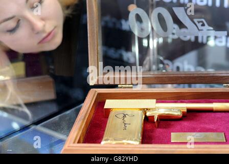 A Bonhams employee looks at a James Bond: The Man with the Golden Gun SD Studios replica gun signed by Roger Moore, estimated between &pound;2500 and &pound;3000, which is part of the forthcoming Entertainment Memorabilia Sale due to take place on June 24th at Bonhams in London. Stock Photo