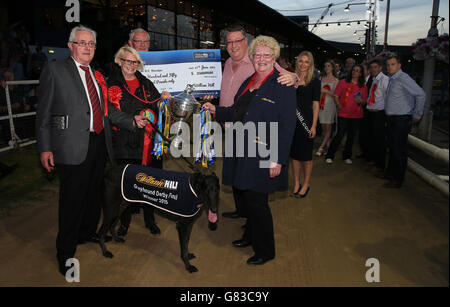 Greyhound Racing - William Hill Derby - Finals - Wimbledon Stadium. Rio Quattro owned and trained by Danny Riordan (left) is presented with the trophy after winning the William Hill Greyhound Derby. Stock Photo