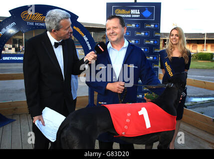 Sky Sports interview trainer Steve Gammon (centre) with dog Jetstream Reason after victory in William Hill Champion Hurdle Final with William Hill logo in view Stock Photo