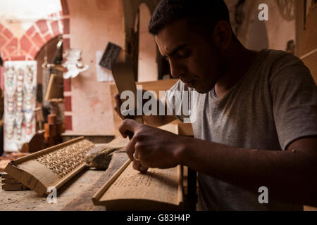 A woodworker artisan works in his workshop in the Marrakesh Medina, Morocco. Stock Photo