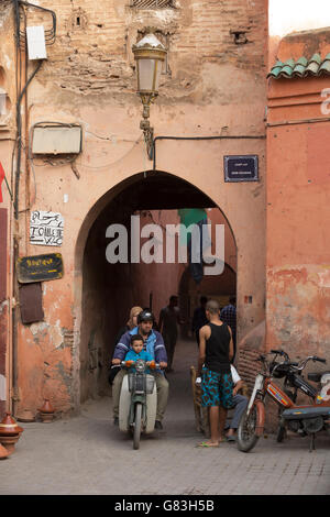 Local residents and tourists dash through the narrow streets of the Marrakesh Medina, Morocco. Stock Photo