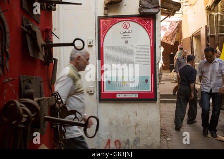 A directional sign for self-guided walking tours helps guide tourists in the old Medina of Fez, Morocco Stock Photo