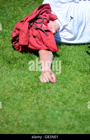 Spectators shield from the sun on Murray Mount during day two of the Wimbledon Championships at the All England Lawn Tennis and Croquet Club, Wimbledon. Stock Photo