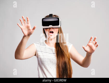 Woman with virtual reality goggles. Studio shot, gray background Stock Photo