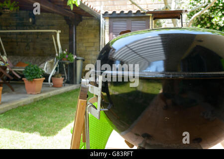 A closed barbecue during pulled pork cooking day, with tools Stock Photo