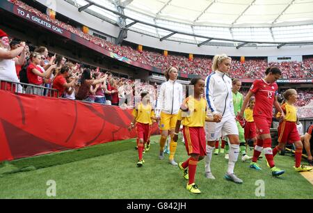 England's Steph Houghton and Canada's Christine Sinclair lead their teams out onto the pitch prior to the FIFA Women's World Cup Canada 2015 Quarter Final match between Canada and England at BC Place Stadium in Vancouver, BC, Canada. Stock Photo