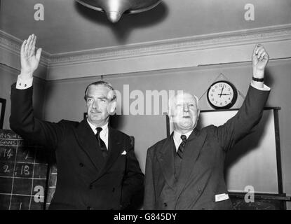 Prime Minister Sir Anthony Eden and Lord Woolton, Chairman of the Conservative Party, raise their arms in response to the cheers of their Party colleagues at Abbey House, Westminster, after the Conservatives were returned to power in the General Election. Stock Photo