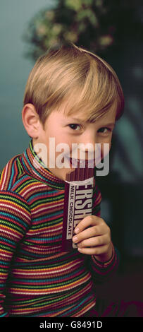 Young boy eating Hershey candy bar Stock Photo