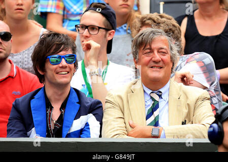 Stephen Fry (right) and Elliott Spencer watch Victoria Azarenka against Serena Williams on day Eight of the Wimbledon Championships at the All England Lawn Tennis and Croquet Club, Wimbledon. Stock Photo