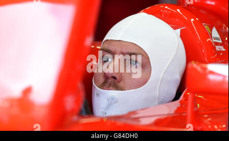 Ferrari driver Sebastian Vettel sits in the garage during Practice on qualifying day for the 2015 British Grand Prix at Silverstone Circuit, Towcester. Stock Photo