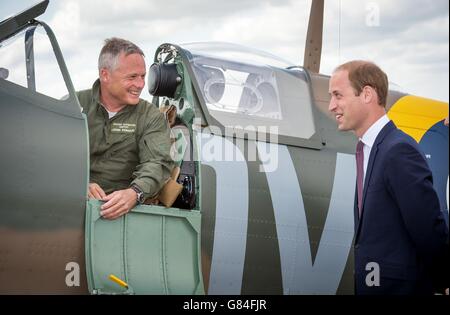 The managing director of the Aircraft Restoration Company (ARC) and pilot John Romain (left) talks to the Duke of Cambridge following a flying display in a newly restored Supermarine Spitfire Mark I N3200 at the Imperial War Museum in Duxford. Stock Photo