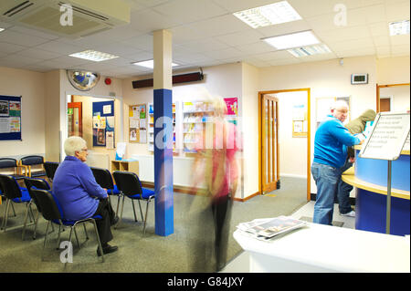 busy and somewhat hectic waiting room in GP health centre practice as patients register for appointments Stock Photo