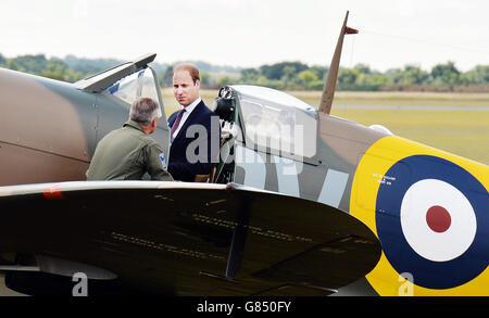 The managing director of the Aircraft Restoration Company (ARC) John Romain (left) talks to the Duke of Cambridge as he sits in a newly restored Supermarine Spitfire Mark I N3200 at the Imperial War Museum in Duxford which he received on behalf of the museum. Stock Photo