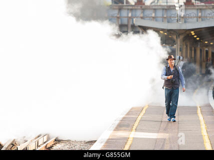 Steam enthusiast David Crosby, from Brisbane, Australia, uses a selfie stick to take a photo with 'Tangmere', a 1947 Battle of Britain class Pacific 4-6-2 steam locomotive, pulling the Dorset Coast Express train to Weymouth at Victoria station, London. Stock Photo