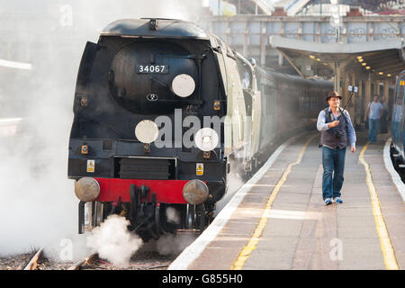 Steam enthusiast David Crosby, from Brisbane, Australia, uses a selfie stick to take a photo with 'Tangmere', a 1947 Battle of Britain class Pacific 4-6-2 steam locomotive, pulling the Dorset Coast Express train to Weymouth at Victoria station, London. Stock Photo