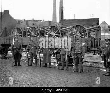 British troops, flanked by two French Poilu's, with captured German guns, at a French base. Stock Photo