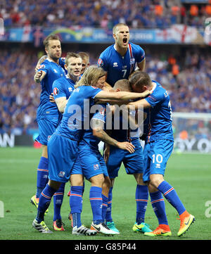 Iceland's Ragnar Sigurdsson (centre, partly hidden) is mobbed by his team-mates as he celebrates scoring his side's first goal during the Round of 16 match at Stade de Nice, Nice, France. Stock Photo