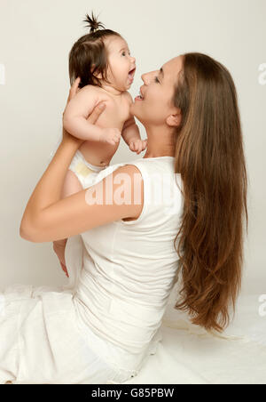 Mom throws baby baby and kiss, play and having fun Stock Photo