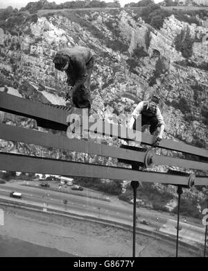 Gilbert Taylor (left) and Alfred Stadon work on the Clifton Suspension Bridge above the Portway at Bristol. They are full-time maintenance men at the structure. Stock Photo