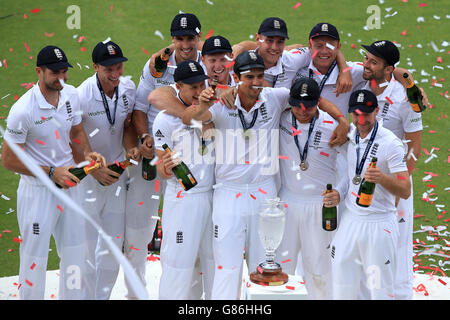 England captain Alastair Cook (centre) lifts the Ashes urn as they celebrate their series win on the podium Stock Photo