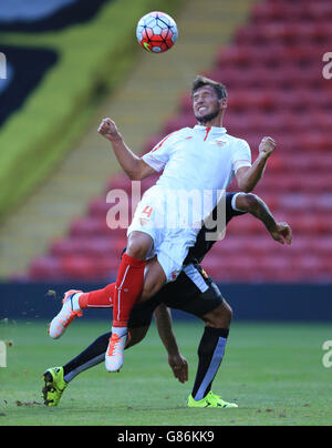 Watford's Troy Deeney (hidden) and Sevilla's Grzegorz Krychowiak battle for the ball during the Pre-Season Friendly match at Vicarage Road, London. Stock Photo