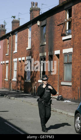 Emergency services personnel outside a house where two women died in a house fire. Police are treating the deaths as suspicious. Stock Photo